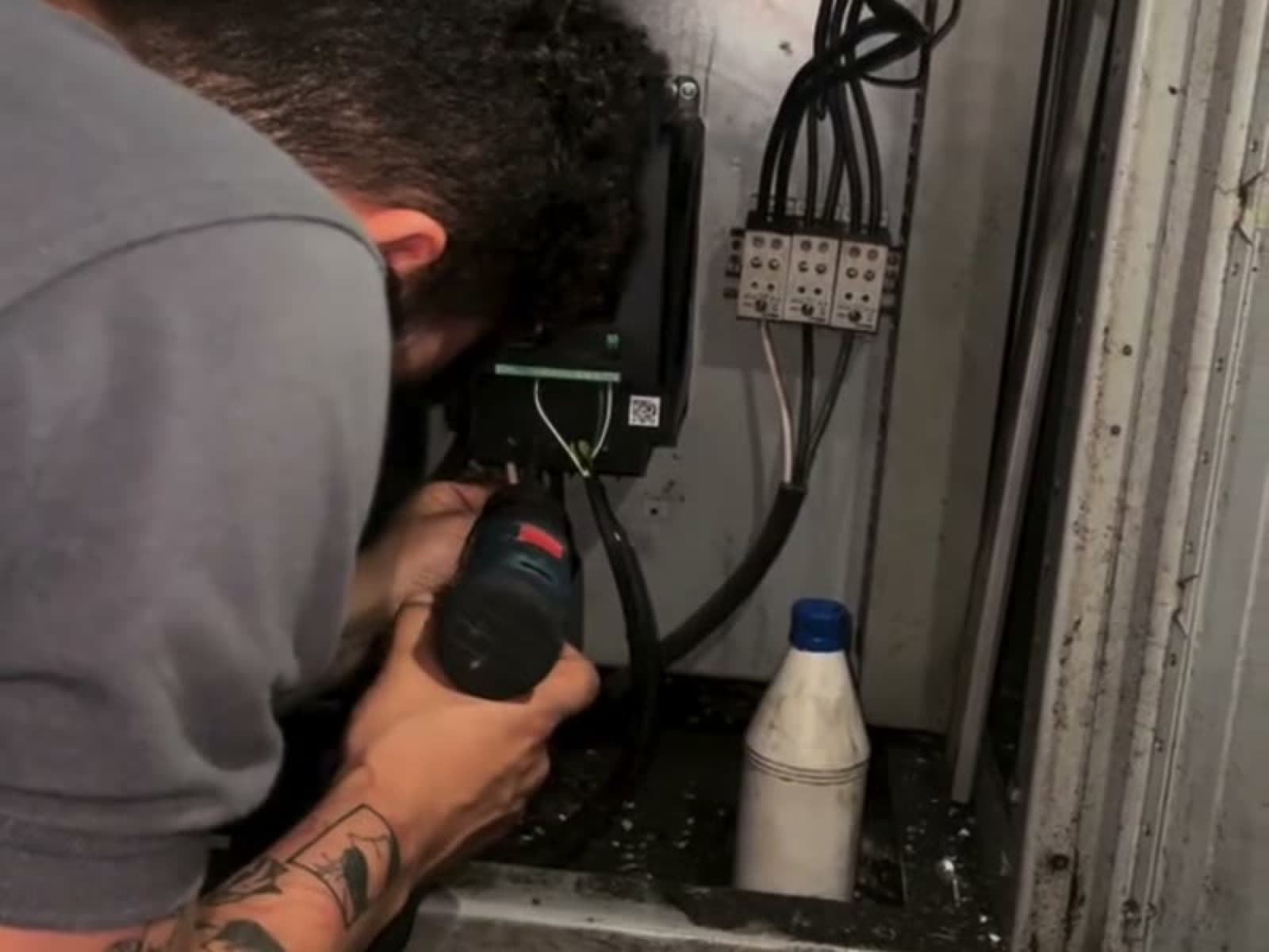 Técnico de SMARTIND midiendo dentro del tablero de una sopladora de plásticos